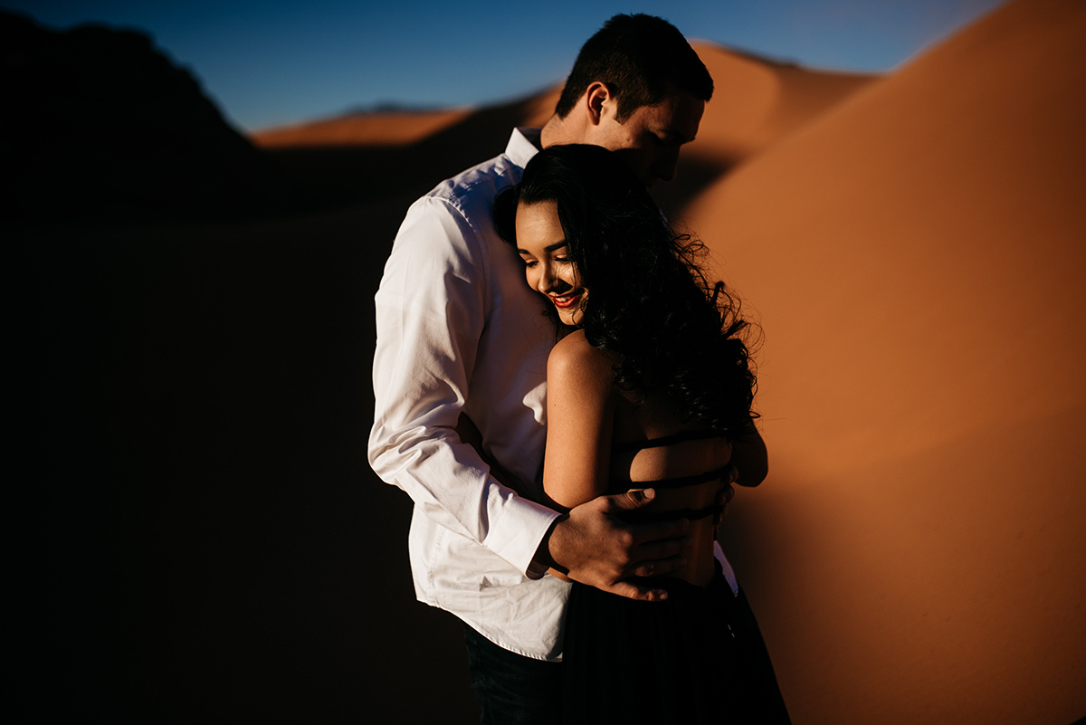 In Utah's bold dunes, a couple's passionate embrace is captured, showcasing emotive posing