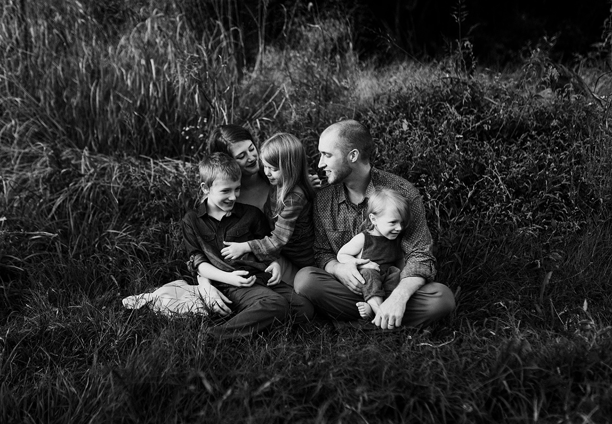 Family laughing together, embodying emotional storytelling in photography in black and white
