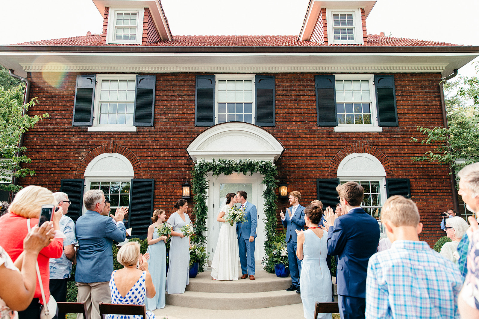A wedding couple gets married on the front steps of her childhood home, where they shared their first kiss in Louisville